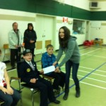 Victoria Vandenbergne presents $880 to Ambassador Luke Belfast